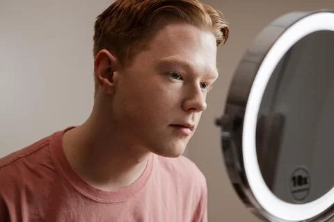 Man Looking into Vanity Mirror Preparing for Skincare Routine Stock Photos
