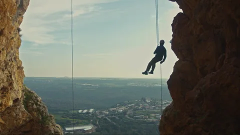 Man Looking At View Suspended From Cliff Stock Footage 275490462