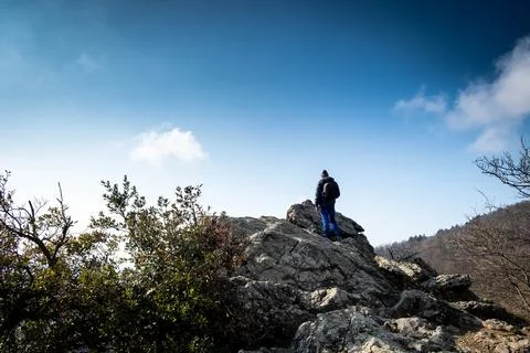 A man is looking at a view from the top of a mountain Stock Photos