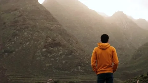 Man looking at the volcanic landscape with mountains in morning fog on sunrise Stock Footage 172272109