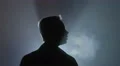The man looks up against a background of bright light. Evening-night time, foggy 4k or 4k+ Resolution