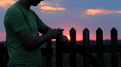 A man looks and touch smart watch at sunset. Beautiful red sky and the sun Stock Footage 65025534