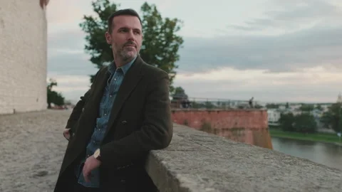 Man looks around while standing on the river embankment Video stock 227135212