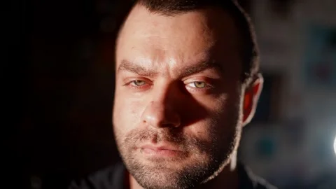 A man looks away with a squint, creating a mysterious  Stock Footage 301310043