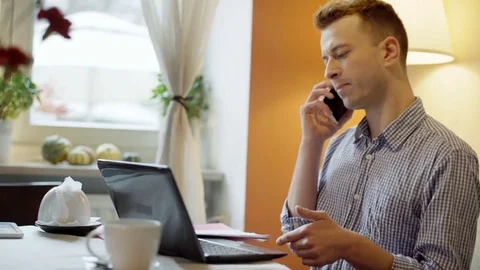 Man looks busy while talking on cellphone about outcomes  Video stock 70684820