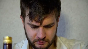 The man looks into the camera and tries to hide, stress, nerves, addiction,alcoh Video stock 86045258