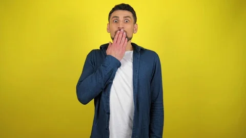 Man looks at the camera, puts his hands to his mouth and is very surprised Stock Footage 119859076