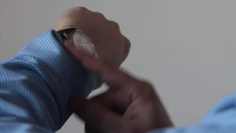 A man looks at the clock on his hand Stock Footage 85427748