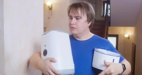 A man looks confused while holding a large manual and a white device Stock Footage 266858609