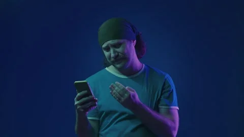 A man looks expectantly at the smartphone screen. The man exhales in Stock Footage 252016725