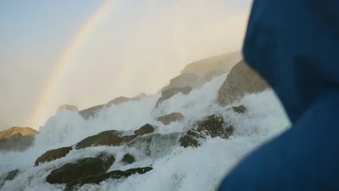 Man looks at fast river. Waterfall. Slowmotion Stock Footage 88058376
