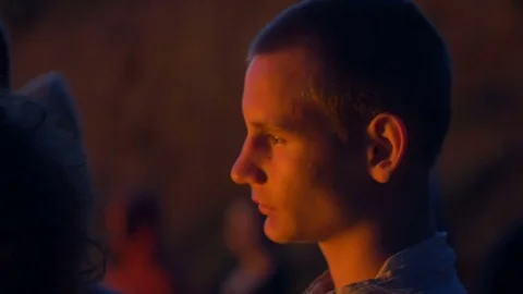 Man looks at the fire with a stony face Stock Footage 82409418