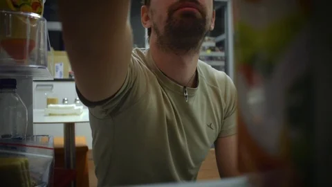 Man looks in the fridge Stock Footage 71042096