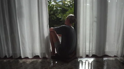 Man looks at garden sitting in panoramic french window Stock Footage 162936613
