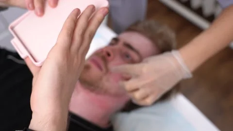 Man looks himself in mirror, examining his beard evaluating work beauty master Vidéo 149483222