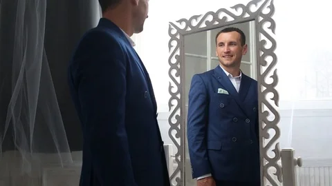Man looks at himself in the mirror Stock Footage 88314207