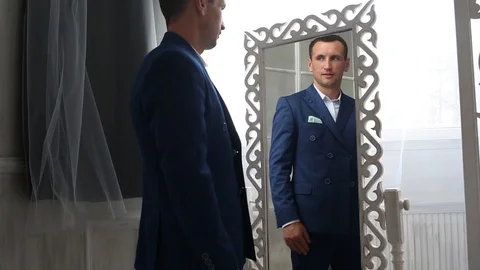 Man looks at himself in the mirror Stock Footage 88314274