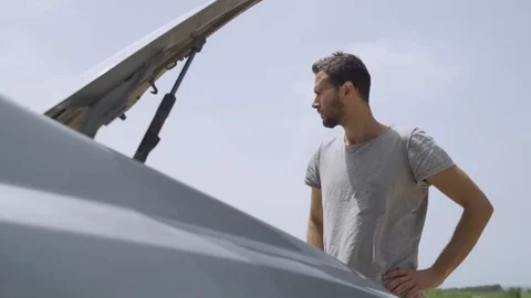 Man looks inside the trunk of his car and walks to the road Stock Footage 107543543