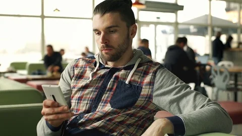 Man looks irritated while waiting for someone in the cafe, steadycam shot 스톡 동영상 73950827