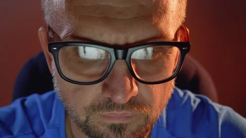 Man looks at laptop screen with face clock on it. Everything is reflected in Stock Footage 101288193