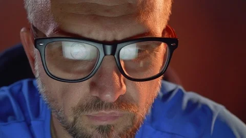 Man looks at laptop screen which is reflected in his glasses and puts cigar in Video stock 101288237