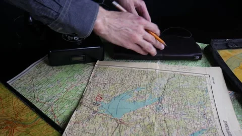 A man looks at a map and writes a route in a notebook Stock Footage 102229448