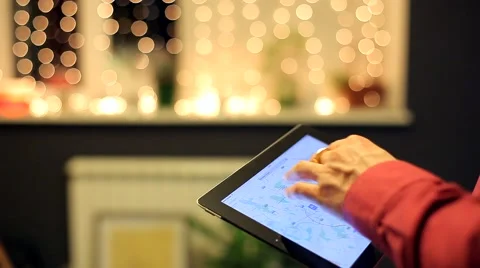 Man Looks at the Map on the Tablet  in the Beautiful Interior on Bokeh Stock Footage 48675610