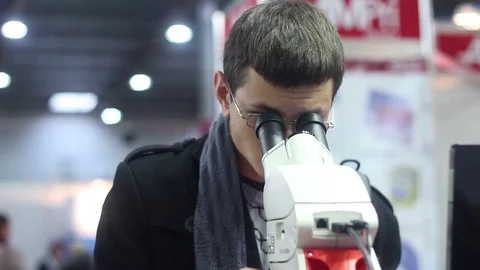 Man looks into the modern laboratory microscope Stock Footage 73387510