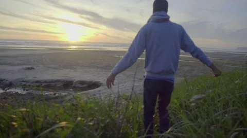Man looks out over open beach Stock Footage 59866443