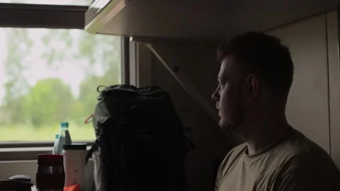 A man looks out of the train window thoughtfully Stock Footage 249418490