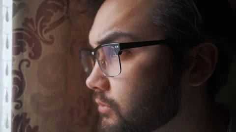 A man looks out the window, but cannot go outside due to quarantine. Stock Footage 127710892