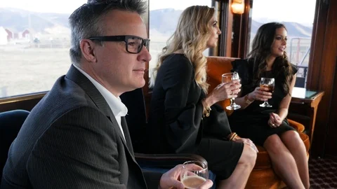 Man looks out window while on boxcar moving train with middle age adults Stock-Footage 117849352