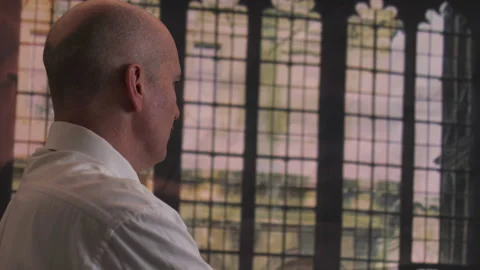 Man Looks Out Windows at Lightning Video stock 236880052