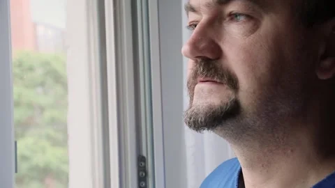 A man looks at the phone standing at the window close-up Stock Footage 245843053