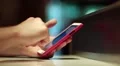 Man looks the photos in his smartphone. Man holds red mobile phone HD Footage