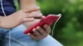 Man looks the photos in smartphone. Man holds red mobile phone HD Footage