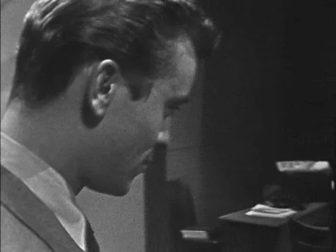 A man looks in on a polygraph machine sitting in the middle of a room in the Stock Footage 75297341
