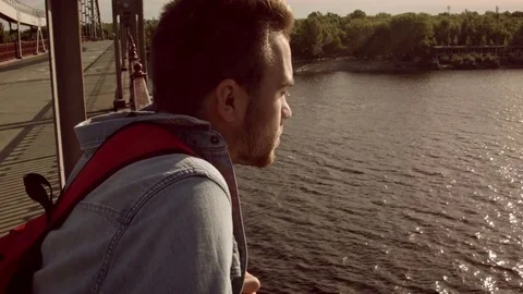 Man looks at the river at dawn Video stock 79734952