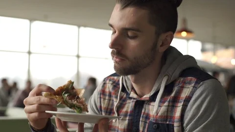 Man looks satisfied while eating tasty pizza in the bistro, steadycam shot Stock-Footage 73953980