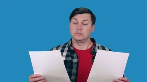 A man looks at sheets with documents, checks the data, reads the document, on a 스톡 동영상 148374342