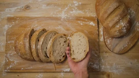 A man looks at a slice of bread in the kitchen. Slice the bread to make a sandwi Stock Footage 148132795