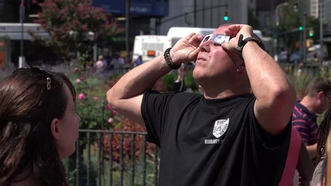 Man looks at a solar eclipse through glasses Stock Footage 79830716