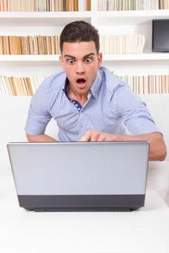 Man looks surprised at content on computer monitor failure Stock Photos
