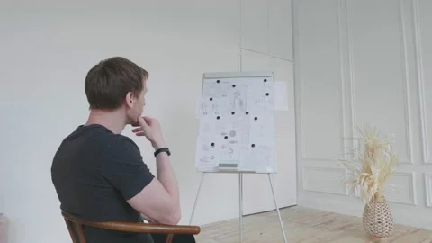 The man looks thoughtfully at the flip chart. Stock Footage 131276003