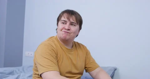 Man looks through big hole in white drywall made with axe Stock Footage 178684643
