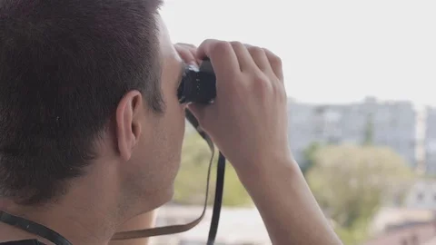 The man looks through binoculars 스톡 동영상 76303551
