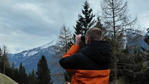Man looks through binoculars at a mountain landscape. Stock Footage 247790535