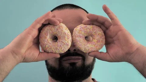 The man looks through the donuts Video stock 243668964