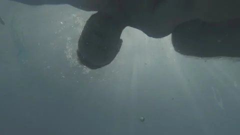 A man looks through the water of the pool at its bottom Stock Footage 163480107