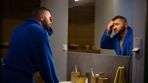 Man looks tired while standing in the bathroom early in the morning and brushing Stock Footage 73789389